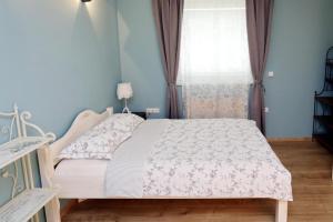 een slaapkamer met een bed met een witte sprei en een raam bij Apartments Life & Energy in Čatež ob Savi