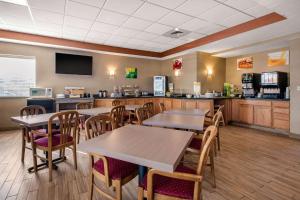 a restaurant with tables and chairs and a kitchen at Quality Inn New Castle in New Castle