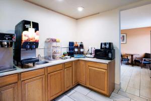 a kitchen with a counter top with a microwave at Rodeway Inn Sergeant Bluff - Sioux City in Sergeant Bluff