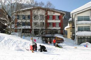 a group of people playing in the snow at Villa Alpen in Yamanouchi
