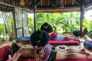 a group of women laying on mats in a room at Phi Phi Relax Beach Resort in Phi Phi Islands