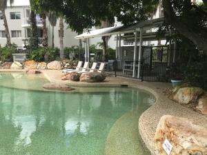 una piscina de agua con 2 sillas y un edificio en Bridgewater Terraces, en Brisbane