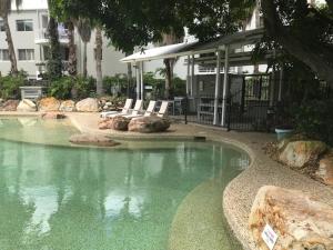 a pool of water with two chairs and a building at Bridgewater Terraces in Brisbane