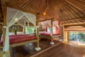 um quarto com uma cama de dossel numa casa em Prana Dewi Mountain Resort em Jatiluwih
