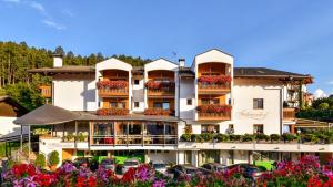 un grande edificio con macchine parcheggiate di fronte di Hotel Föhrenhof a Naz-Sciaves