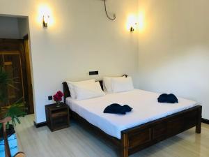 Un dormitorio con una cama con dos sombreros. en Oasis Bay en Arugam Bay