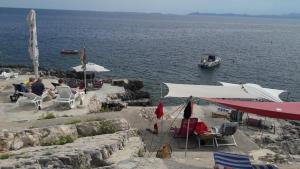 a group of people sitting in chairs near the water at Foissner Apartments in Zavalatica