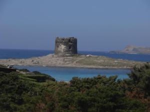 a castle on an island in the water at La Dea Madre in Stintino
