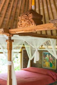 a wooden bed with a canopy in a room at Prana Dewi Mountain Resort in Jatiluwih