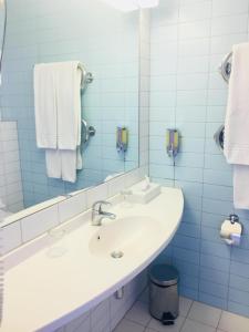 a bathroom with a sink and a mirror and towels at Green Park Hotel Klaipeda in Klaipėda