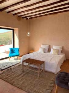 een slaapkamer met een groot bed en een blauwe stoel bij La Villa Berbère in Marrakesh