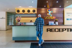 a man standing at the counter of a restaurant at Vogue Pattaya Hotel in Pattaya Central