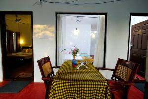a dining room with a table and chairs and a window at Marari Lotus Beach Villa in Mararikulam
