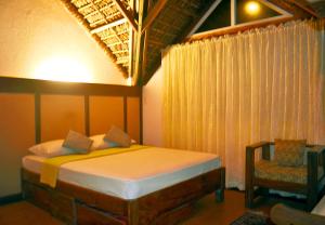 a bedroom with a bed and a chair at Alta Vista Ilocandia Inc. in Pagudpud