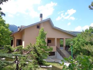 ein Haus in den Bergen mit Bäumen in der Unterkunft Villa Miralago in Fiastra