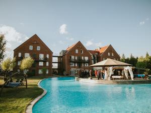 a group of people standing in front of a swimming pool at Landhotel Beverland bei Münster in Ostbevern