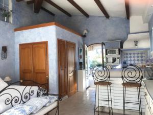 a bedroom with two iron beds and a kitchen at Vallis Aurea in Grasse