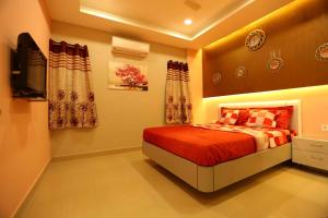 a bedroom with a bed and a flat screen tv at Babukala Regency in Kanchipuram
