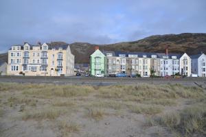 a row of buildings in front of a beach at Môr Wyn Guest House in Barmouth