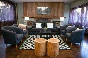 uma sala de estar com um sofá e duas cadeiras e uma mesa em RVHotels Condes del Pallars em Rialp