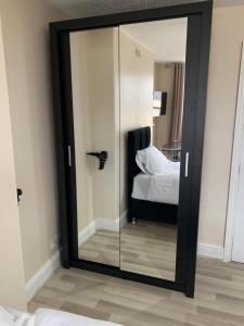 a large mirror in a room with a bed at Cotswold Valley Aparthotel in Stroud