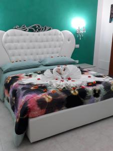 een slaapkamer met een bed met een wit bedframe bij Affitta Camere Romy in Tropea