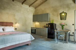 a bedroom with a bed and a table and a kitchen at Villa Daniela - Saint Nikolas Retreat in Faraklata