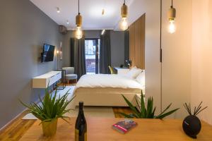 a bedroom with a bed and a table with a bottle of wine at Urban Oasis Apartments with Parking in Bucharest