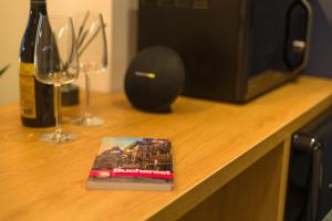 a book sitting on top of a counter with wine glasses at Urban Oasis Apartments with Parking in Bucharest