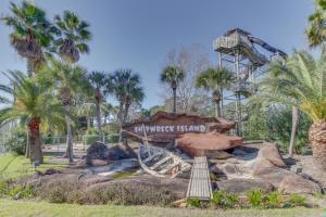 パナマ・シティ・ビーチにあるThe Splash Resort and Condos Westのヤシの木が茂る公園のジェットコースター