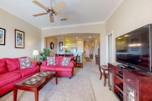 sala de estar con sofás rojos y TV de pantalla plana en 1000 Cinnamon Beach, en Palm Coast