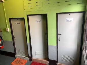 una fila de tres ascensores en un edificio en J Giant Hostel, en Chiang Mai