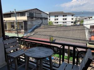 Una mesa y una silla en un balcón con vista. en J Giant Hostel, en Chiang Mai