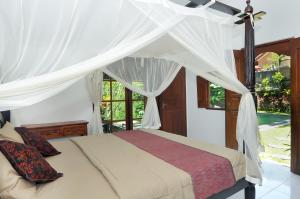 Postel nebo postele na pokoji v ubytování Yuliati House Ubud