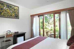 Postel nebo postele na pokoji v ubytování Yuliati House Ubud