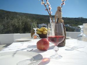 a table with a glass of wine and an apple on it at Vrahos Agios Romanos in Agios Romanos