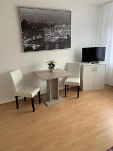 ein Esszimmer mit einem Tisch, 2 Stühlen und einem TV in der Unterkunft Zentrales WG-Zimmer 3 in Ravensburg stadtnah in Ravensburg