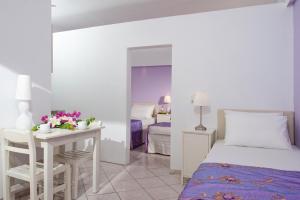 a bedroom with a bed and a desk with a table at Primavera Beach Hotel Studios & Apartments in Malia