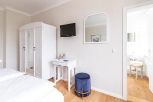 een slaapkamer met een bed, een bureau en een spiegel bij Hotel Am Sommerbad in Halberstadt