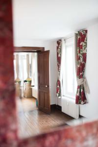 a room with a door and windows with curtains at Le Tout à Pied et son parking privé in Étretat