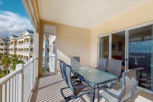 a balcony with a glass table and chairs on it at 1000 Cinnamon Beach in Palm Coast