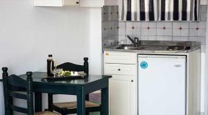 a small kitchen with a table and a sink at Christina Perlia Studios in Poros