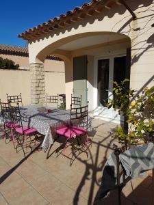 a patio with a table and chairs on a house at fleur de garance in Le Thor