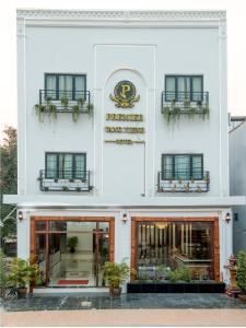 un bâtiment blanc avec un front de magasin avec des plantes en pot dans l'établissement Premier Vang Vieng Hotel, à Vang Vieng