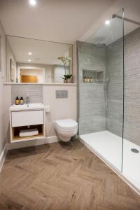 a bathroom with a shower and a toilet and a sink at West House, 36A Whitstable Road in Canterbury