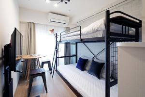 Cette chambre comprend deux lits superposés et un bureau. dans l'établissement KARIO SASAZUKA TERRACE, à Tokyo