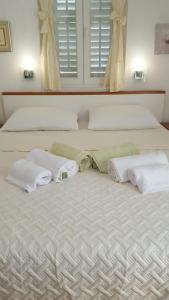 a bedroom with two beds with white towels on it at Apartment Petricic in Postira