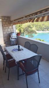 a table and chairs on a patio with a view at Apartment Petricic in Postira