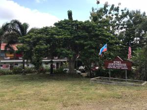 a tree with a sign in front of a building at RTMS Guesthouse Semporna in Semporna