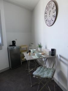 una habitación con una mesa y un reloj en la pared en Les Doctrinaires en Brive-la-Gaillarde